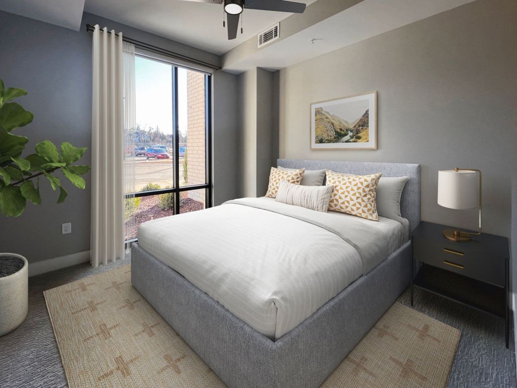 Carraway Village bedroom with plush carpeting, large windows, vaulted ceiling, and modern bedroom furniture