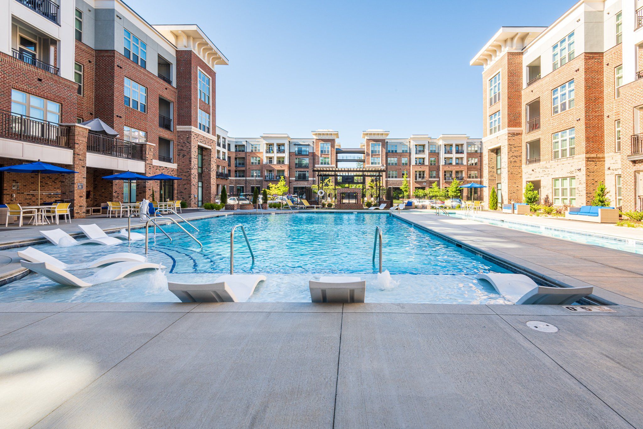 Outdoor pool amenity at Carraway Village with lounge chairs