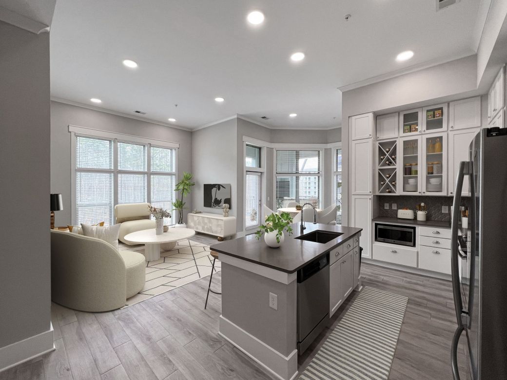 Beautiful apartment living and dining area with large windows, large kitchen island, and stainless steel appliances