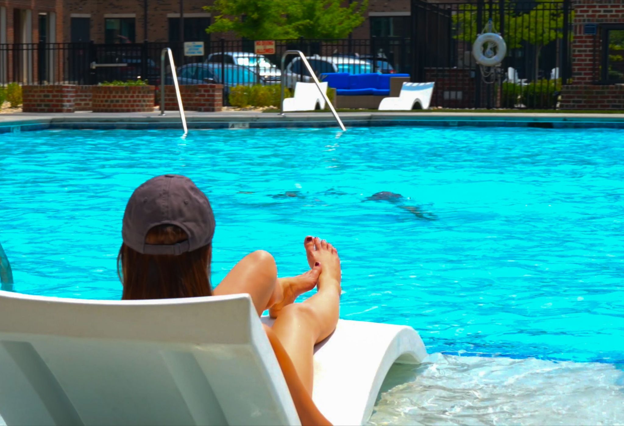 Large resort-inspired pool with beautiful blue water and surrounding lounge seating